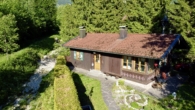 Luftaufnahme - Der Traum vom eigenen kleinen Haus am Bach mit Bergblick
