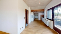 Wohnbereich mit großzügiger Fensterfront und Westbalkon