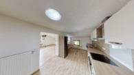 Küche mit Zugang zum Wohnzimmer - Stilvolle 4-Zimmer-Dachgeschosswohnung im kernsanierten Bauernhaus mit Bergblick