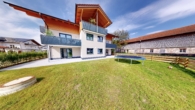 Hausansicht mit Garten - Neubau: Traumhaft lichtdurchflutete vier Zimmer Erdgeschosswohnung in Übersee Feldwies